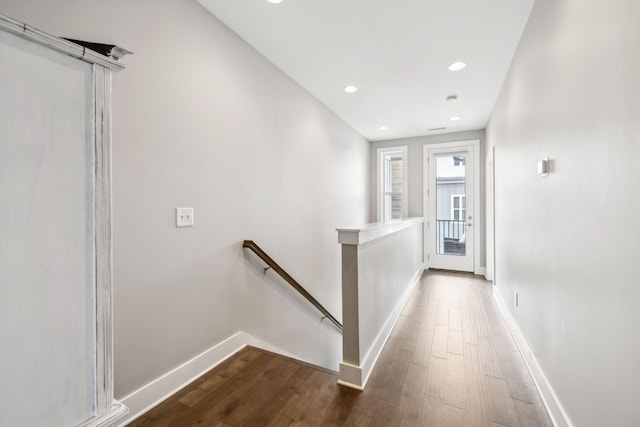 corridor featuring dark wood-style flooring, recessed lighting, an upstairs landing, and baseboards