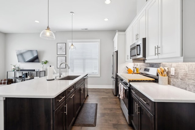 kitchen featuring light countertops, appliances with stainless steel finishes, a sink, and white cabinetry