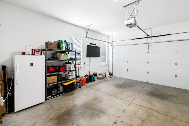 garage featuring a garage door opener and freestanding refrigerator