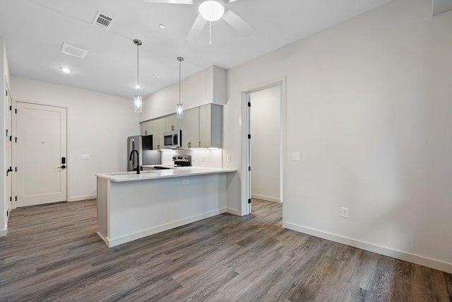 kitchen featuring a peninsula, visible vents, light countertops, appliances with stainless steel finishes, and pendant lighting