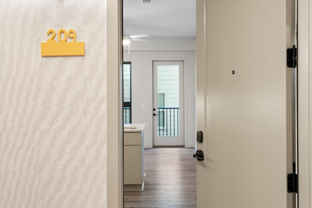 corridor featuring light wood-style floors, visible vents, and baseboards