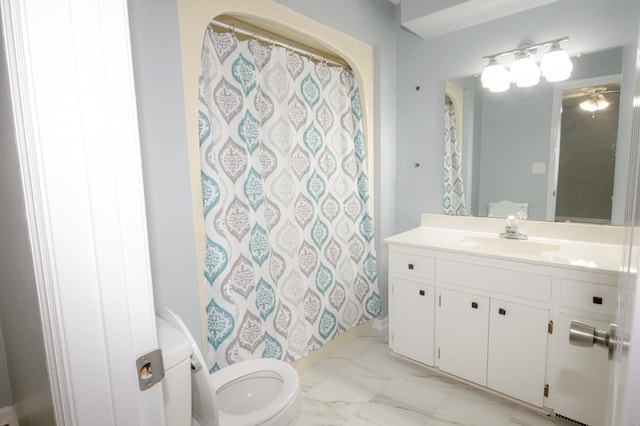 bathroom featuring toilet, marble finish floor, and vanity