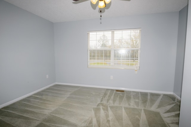 unfurnished room featuring a textured ceiling, ceiling fan, carpet, and baseboards