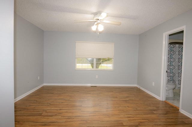 unfurnished room featuring a ceiling fan, a textured ceiling, baseboards, and wood finished floors