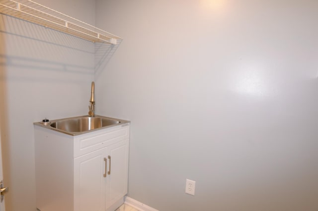 washroom with a sink and baseboards