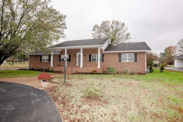 view of front of home with brick siding and a front lawn