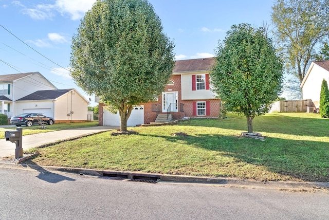 view of front of house featuring a garage, driveway, fence, a front yard, and brick siding