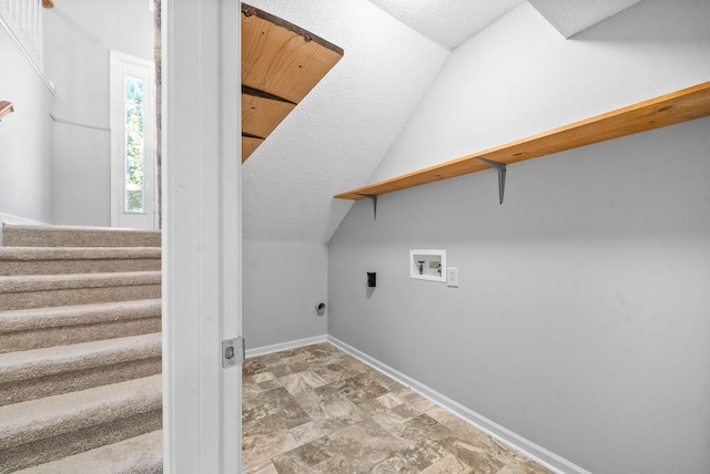 clothes washing area with washer hookup, laundry area, a textured ceiling, and baseboards