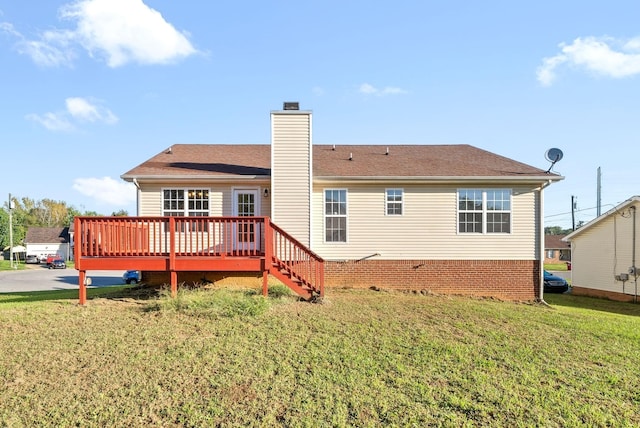 back of property with a chimney, a wooden deck, and a lawn