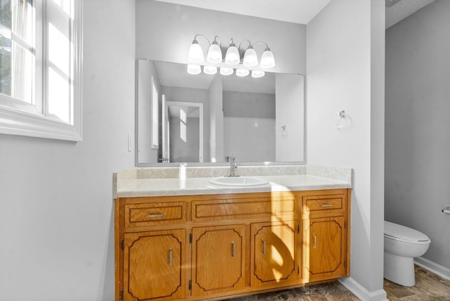 bathroom featuring toilet, baseboards, and vanity