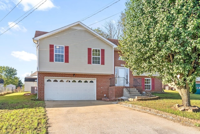 tri-level home with an attached garage, cooling unit, brick siding, driveway, and a front yard