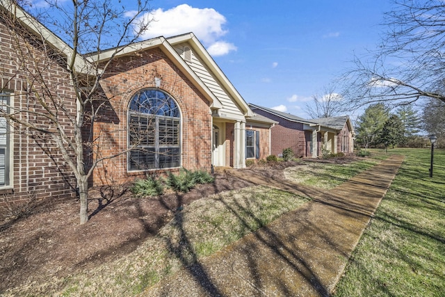 view of home's exterior with a yard and brick siding