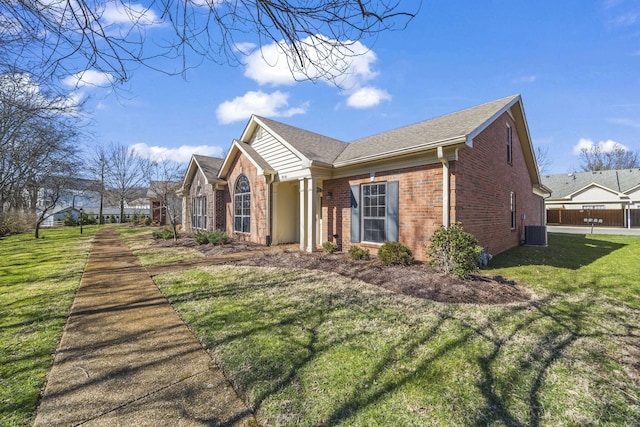 view of home's exterior with a yard, brick siding, and central air condition unit