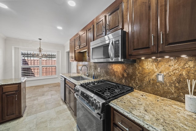 kitchen with stainless steel appliances, a sink, baseboards, tasteful backsplash, and stone tile flooring