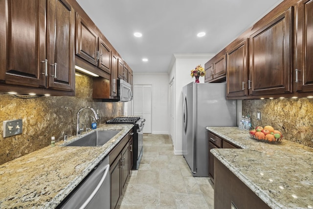 kitchen with stainless steel appliances, crown molding, a sink, and light stone counters