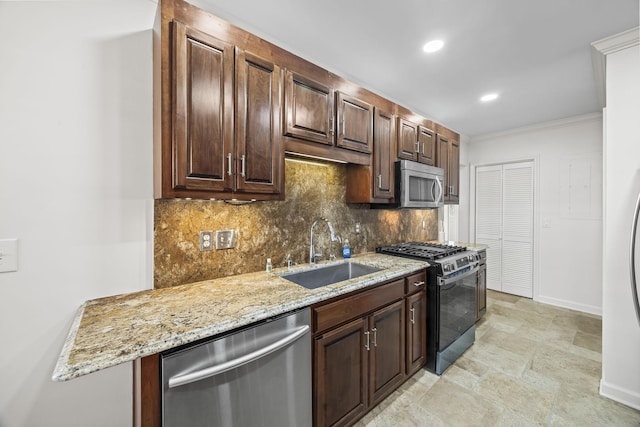 kitchen with stainless steel appliances, tasteful backsplash, a sink, light stone countertops, and baseboards