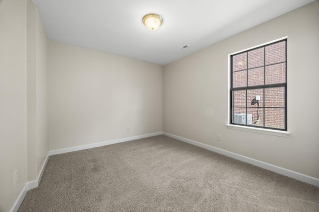 carpeted empty room featuring baseboards and visible vents