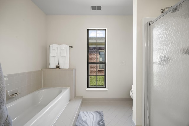 full bathroom featuring tile patterned flooring, visible vents, a wealth of natural light, and a shower stall