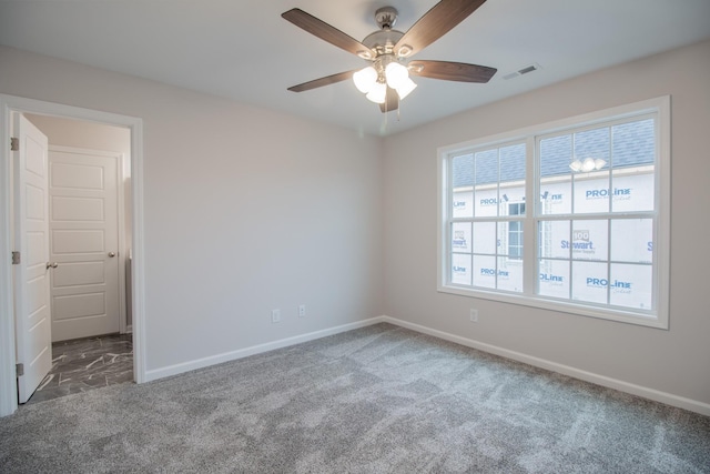 carpeted empty room featuring baseboards, visible vents, and a ceiling fan