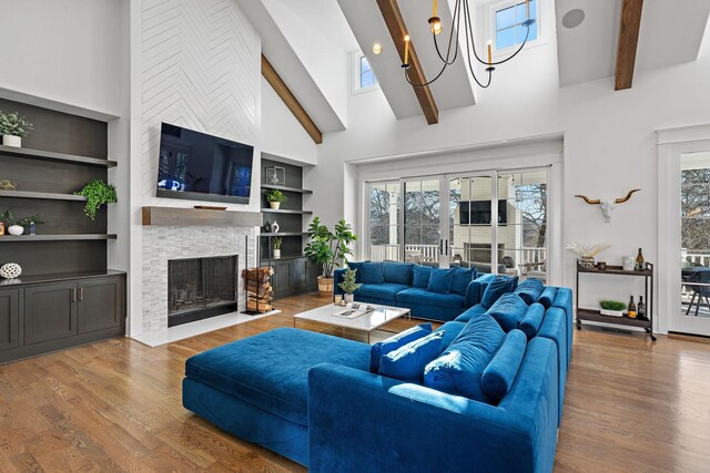 living room with a healthy amount of sunlight, wood finished floors, and beamed ceiling