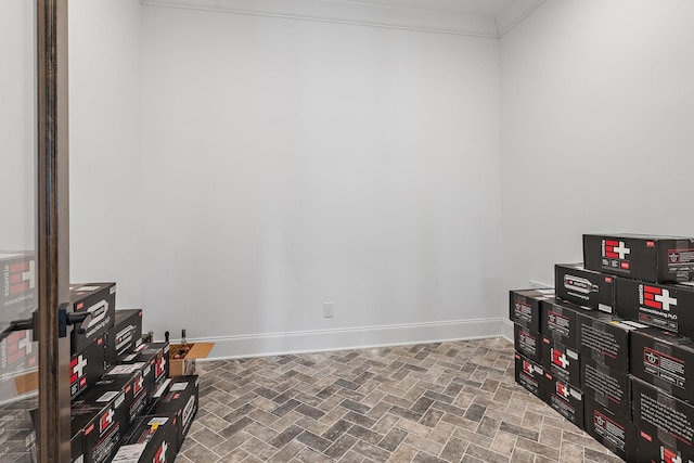 miscellaneous room featuring ornamental molding, brick floor, and baseboards