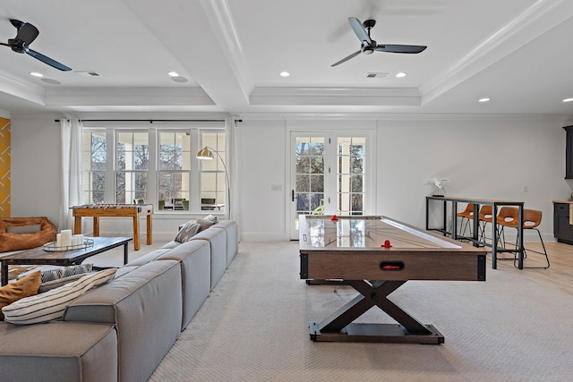 game room with ceiling fan, a tray ceiling, and ornamental molding