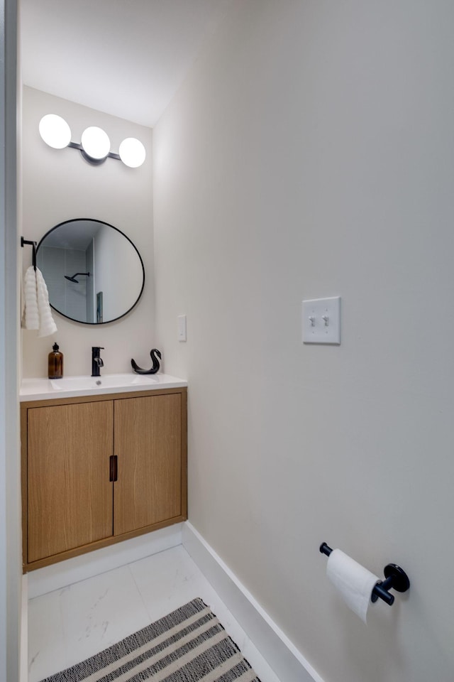 bathroom featuring marble finish floor, vanity, and baseboards