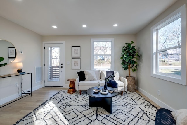 living area featuring light wood-type flooring, baseboards, visible vents, and recessed lighting