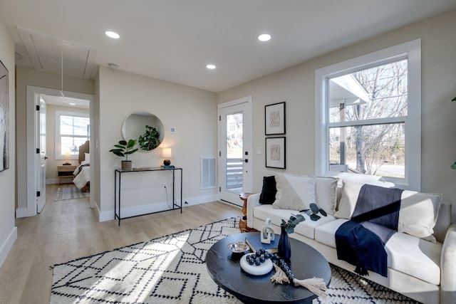 living room featuring recessed lighting, visible vents, baseboards, light wood-type flooring, and attic access