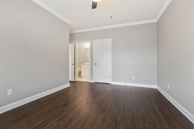 empty room with ornamental molding, dark wood-style flooring, baseboards, and a ceiling fan