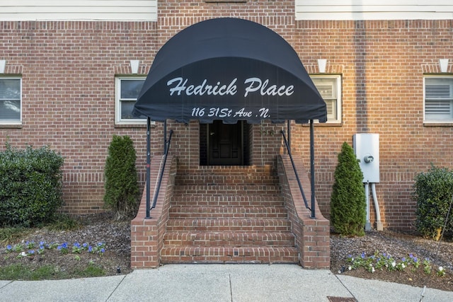 property entrance featuring brick siding