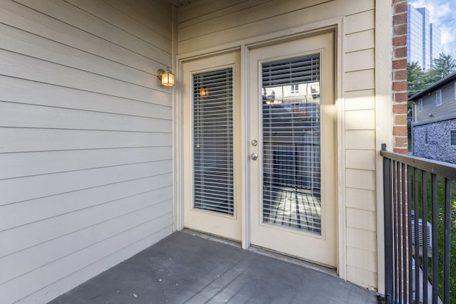 view of exterior entry with a balcony