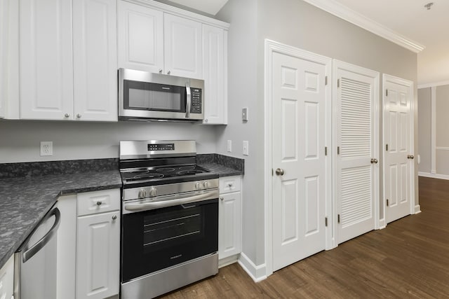 kitchen featuring dark wood-type flooring, white cabinets, appliances with stainless steel finishes, dark countertops, and crown molding