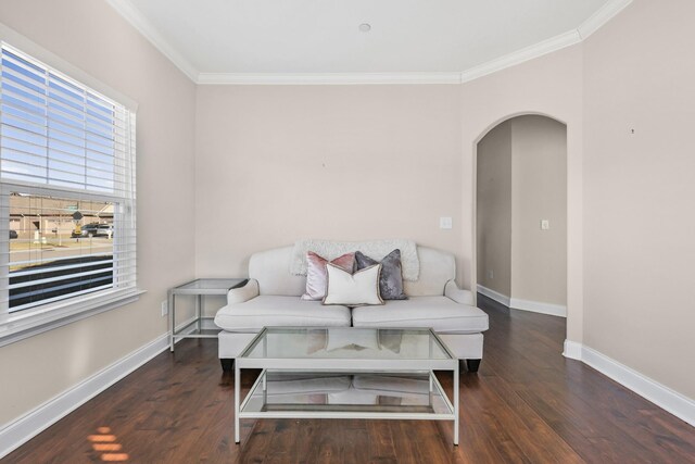 living room with arched walkways, crown molding, wood finished floors, and baseboards