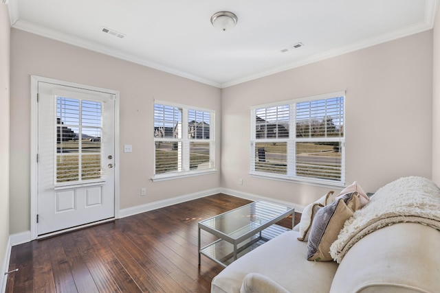 living room with ornamental molding, hardwood / wood-style flooring, visible vents, and baseboards