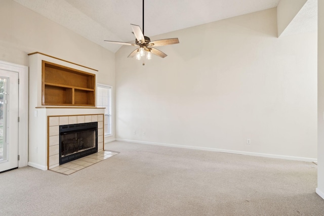 unfurnished living room with light colored carpet, a tile fireplace, a healthy amount of sunlight, and baseboards