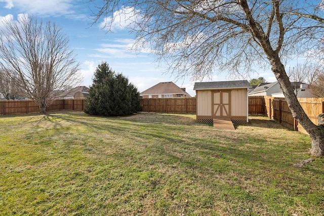 view of yard with a fenced backyard, an outdoor structure, and a storage unit