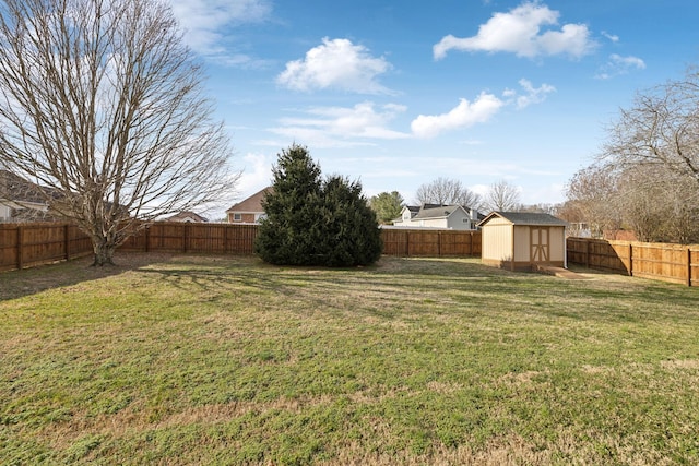 view of yard with a storage shed, an outbuilding, and a fenced backyard