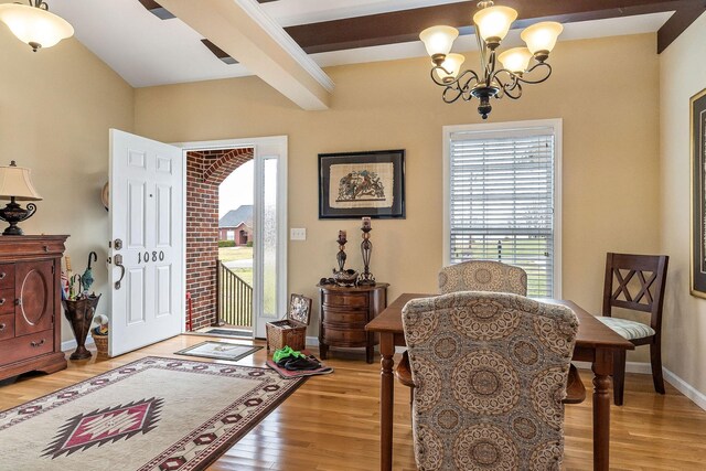 interior space with baseboards, wood finished floors, beam ceiling, and an inviting chandelier