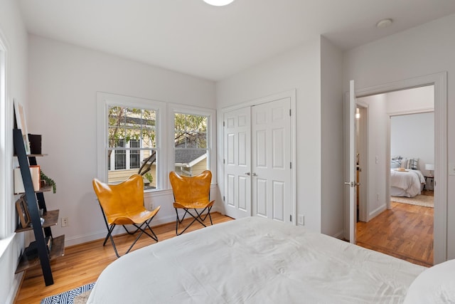 bedroom with a closet, wood finished floors, and baseboards