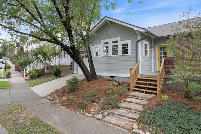 view of front of property with crawl space, a garage, stairway, and concrete driveway