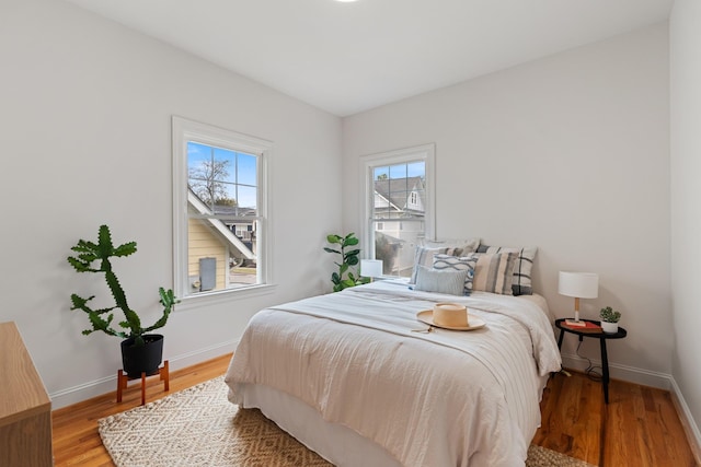 bedroom with baseboards and wood finished floors