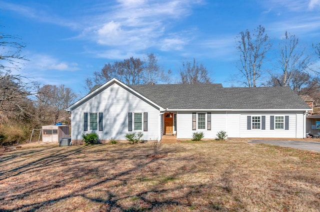 ranch-style house with a shingled roof and a front yard