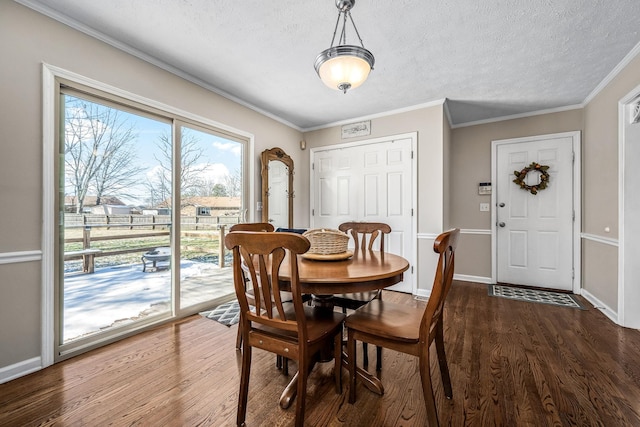 dining room featuring a textured ceiling, dark wood finished floors, and crown molding