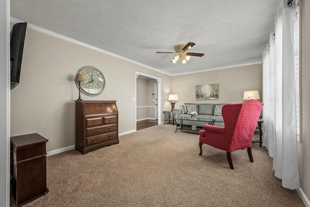 sitting room with carpet floors, baseboards, ornamental molding, and a textured ceiling