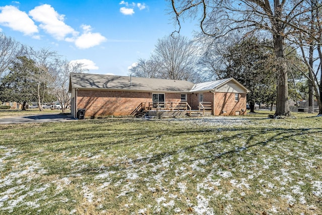 rear view of property featuring a lawn and brick siding