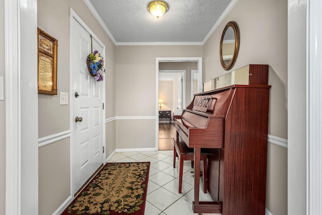 foyer entrance with light tile patterned floors, a textured ceiling, baseboards, and crown molding