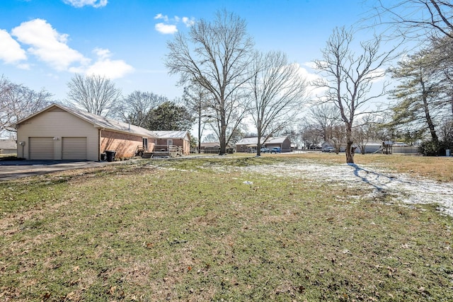 view of yard featuring aphalt driveway and an attached garage