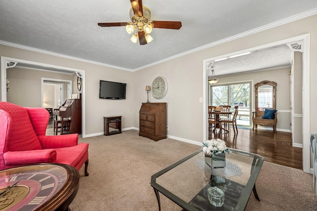 carpeted living room featuring crown molding, baseboards, and a textured ceiling