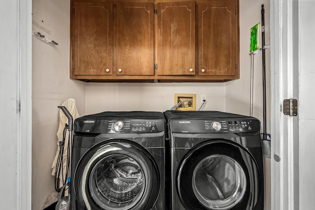 washroom with cabinet space and washer and clothes dryer